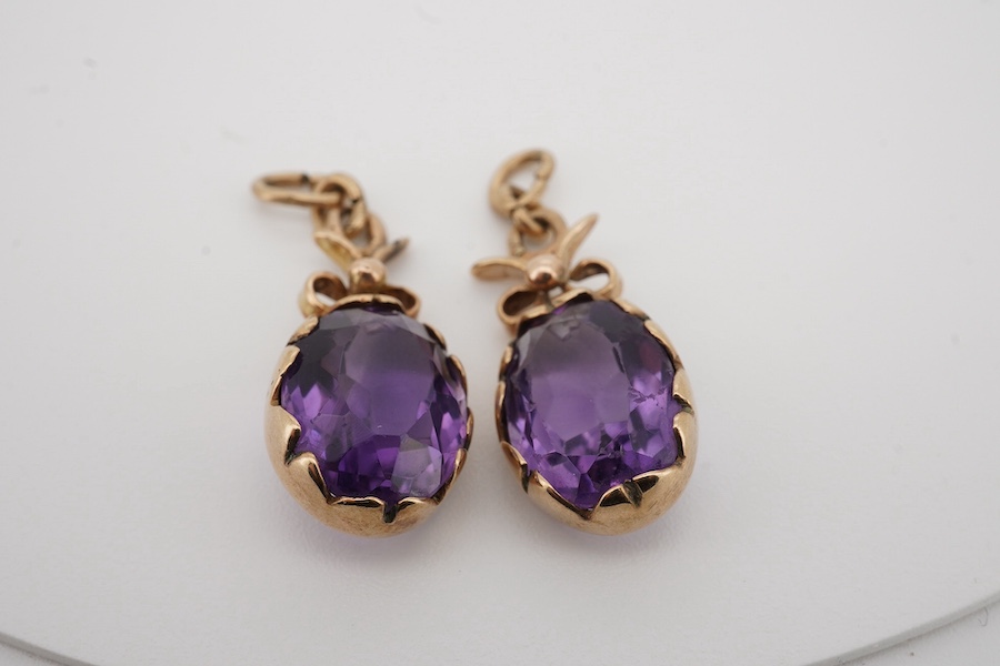 A pair of yellow metal and oval cut amethyst set drop earrings, lacking fittings, overall 28mm. Condition - poor to fair